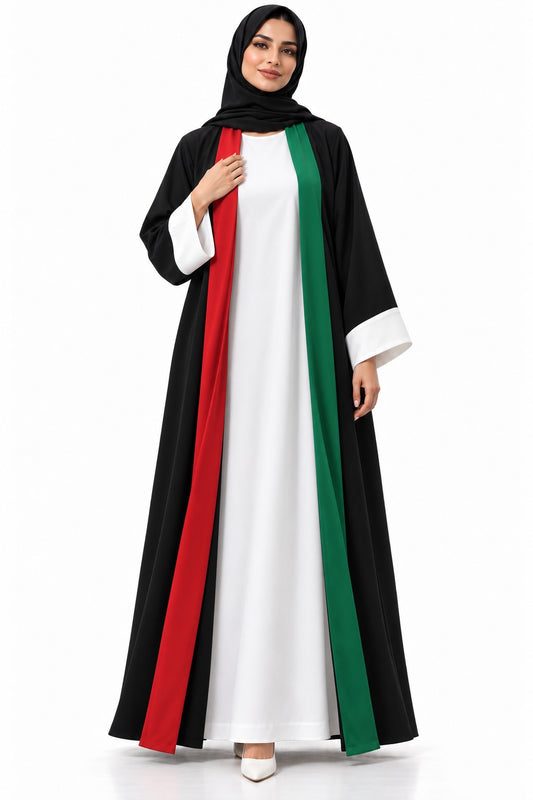 Woman in black Nida open abaya with red and green front bands, white cuffs and white inner dress, hand on heart for UAE National Day